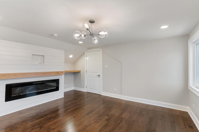 unfurnished living room with an inviting chandelier, dark wood-type flooring, and lofted ceiling