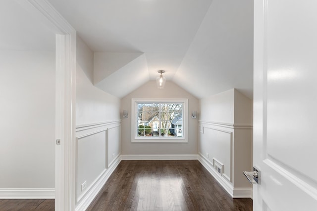 bonus room featuring dark wood-type flooring and vaulted ceiling