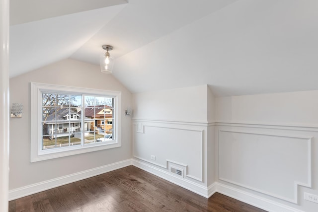 bonus room with lofted ceiling and dark hardwood / wood-style floors