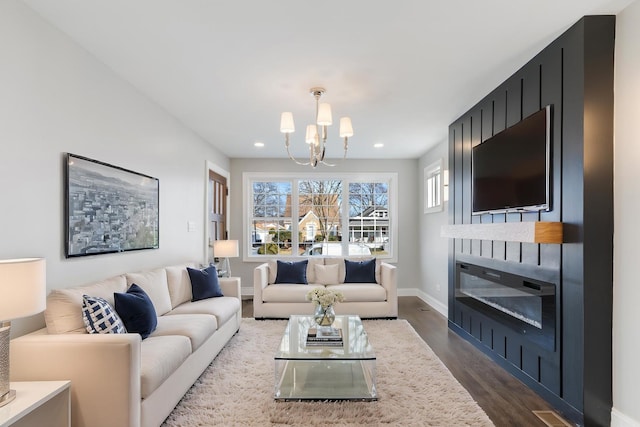 living room with dark wood-type flooring and a notable chandelier