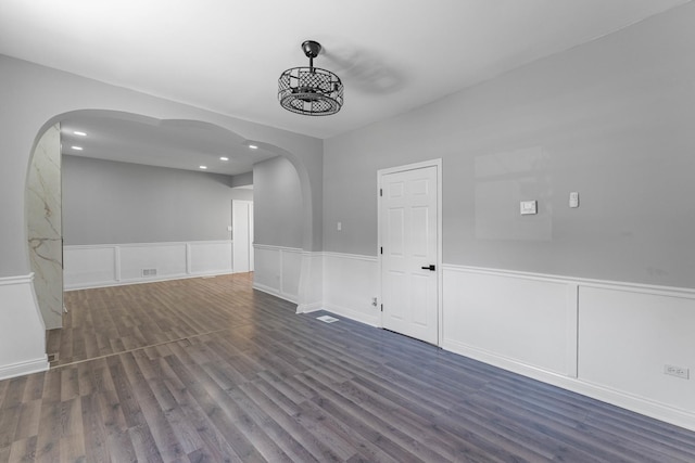 unfurnished room with dark wood-type flooring and a notable chandelier