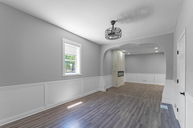 unfurnished room featuring a chandelier and dark hardwood / wood-style flooring