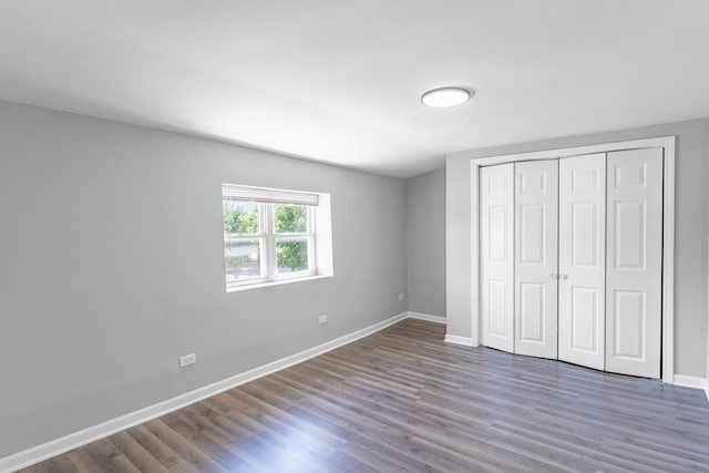 unfurnished bedroom featuring dark hardwood / wood-style flooring and a closet