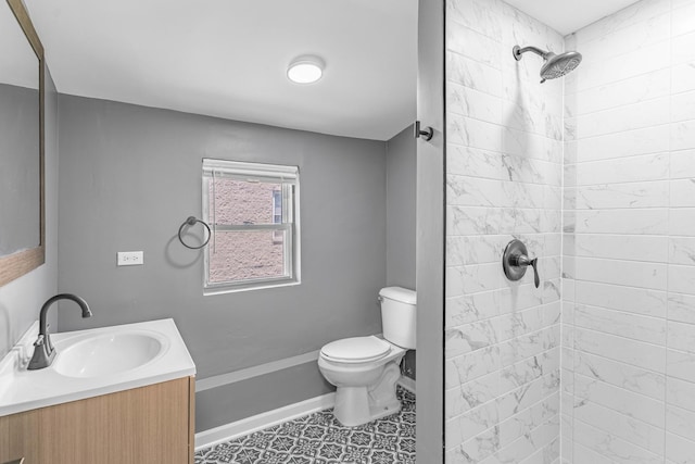 bathroom featuring tile patterned flooring, vanity, tiled shower, and toilet