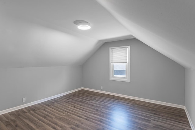 bonus room with dark wood-type flooring and lofted ceiling