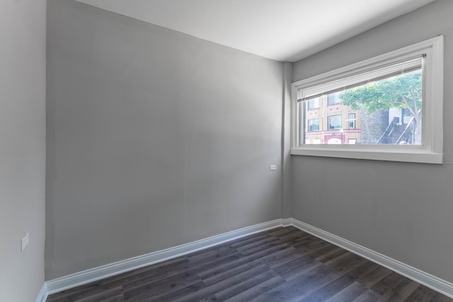 unfurnished room with dark wood-type flooring