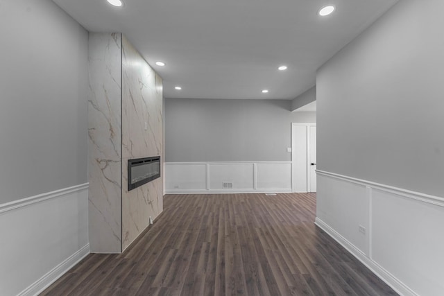 interior space featuring dark hardwood / wood-style floors, heating unit, and a premium fireplace