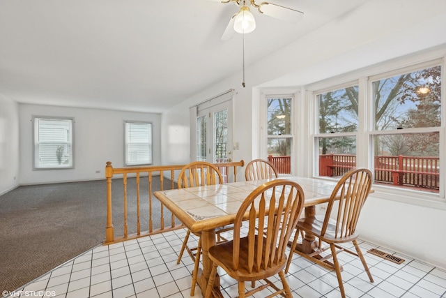 carpeted dining room featuring ceiling fan