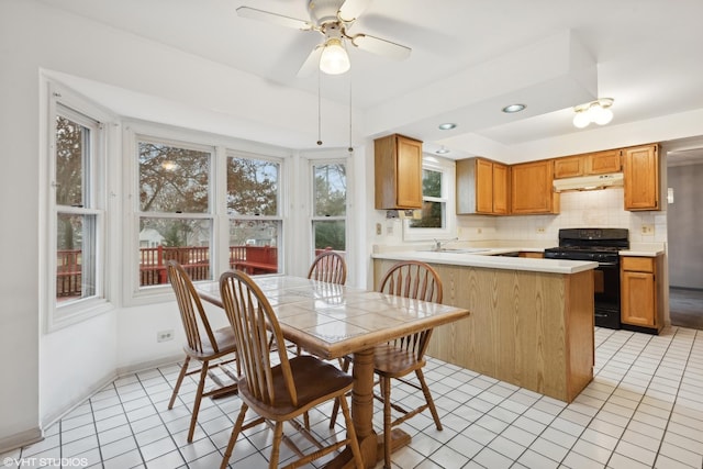 kitchen with tasteful backsplash, sink, black range with gas stovetop, ceiling fan, and kitchen peninsula