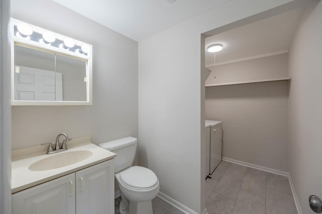 bathroom with washer and clothes dryer, vanity, and toilet