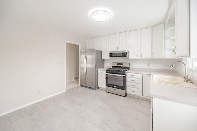 kitchen featuring sink, white cabinets, and appliances with stainless steel finishes