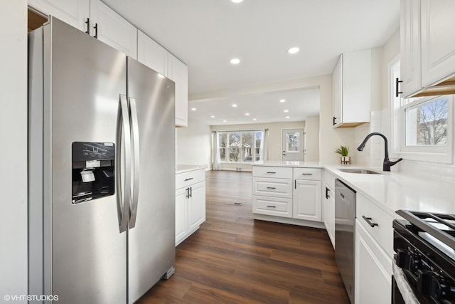 kitchen featuring stainless steel appliances, white cabinetry, dark wood-type flooring, and sink