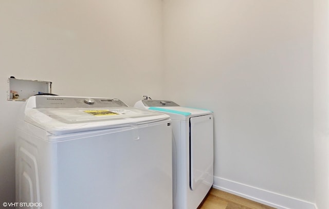 laundry room featuring washing machine and dryer and light hardwood / wood-style floors