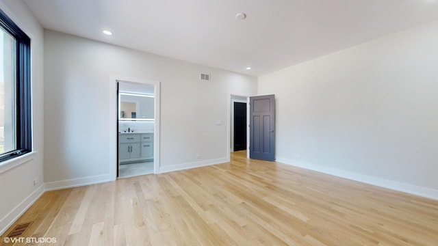 unfurnished bedroom featuring light hardwood / wood-style floors and ensuite bathroom