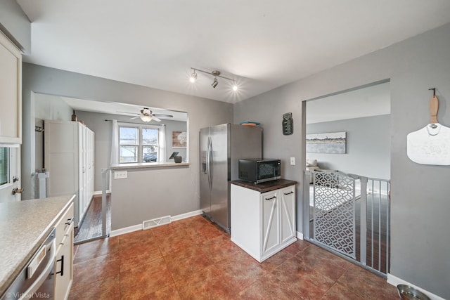 kitchen featuring ceiling fan, white cabinetry, stainless steel appliances, and track lighting