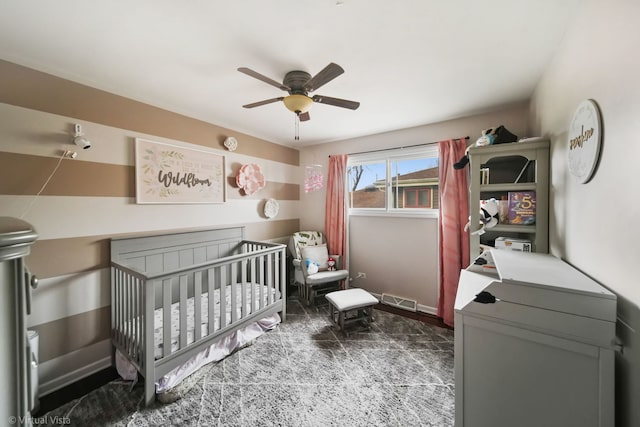 bedroom with ceiling fan and a nursery area