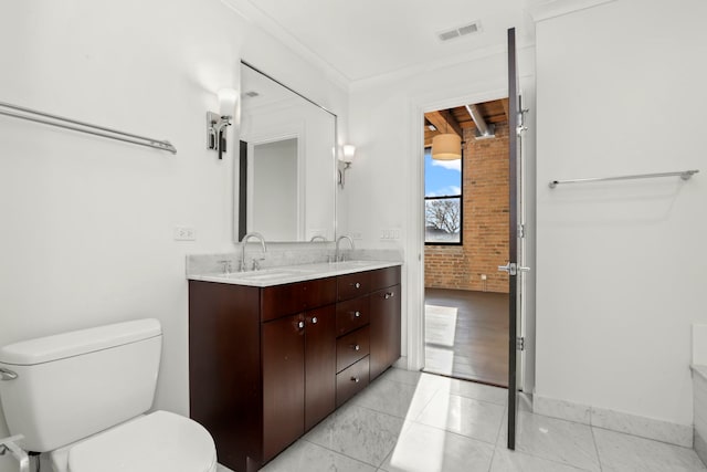 bathroom with brick wall, tile patterned flooring, vanity, toilet, and ornamental molding