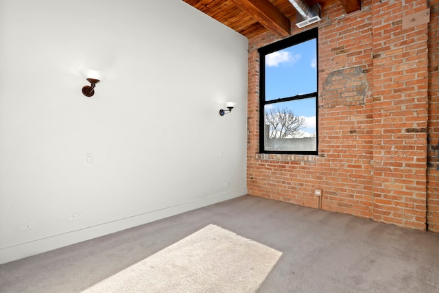 empty room featuring lofted ceiling with beams, wooden ceiling, carpet flooring, and brick wall