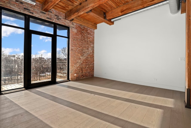 unfurnished room with hardwood / wood-style flooring, beamed ceiling, a healthy amount of sunlight, and wooden ceiling