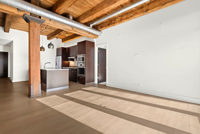 unfurnished living room featuring sink, beamed ceiling, hardwood / wood-style floors, and wooden ceiling