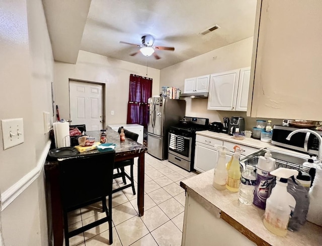 kitchen featuring white cabinets, light tile patterned floors, stainless steel appliances, and ceiling fan