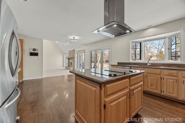 kitchen with a kitchen island, stainless steel refrigerator, sink, island exhaust hood, and black electric stovetop