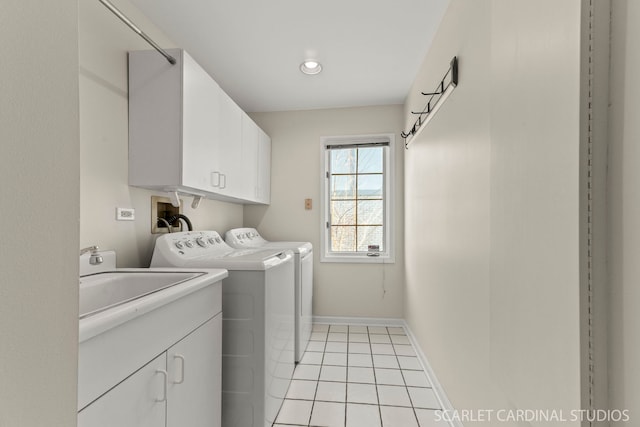 clothes washing area with cabinets, washing machine and clothes dryer, and light tile patterned floors