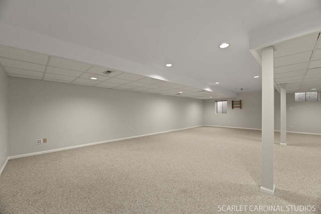 basement featuring light carpet and a drop ceiling