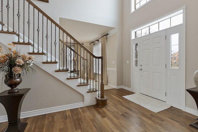 foyer entrance with hardwood / wood-style floors and a high ceiling