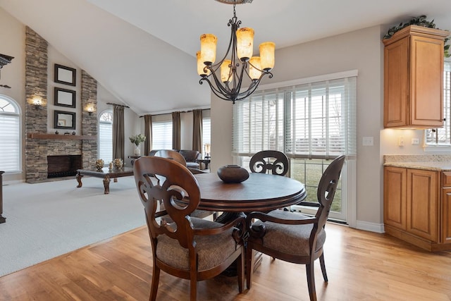 dining room with a fireplace, light hardwood / wood-style floors, and a healthy amount of sunlight