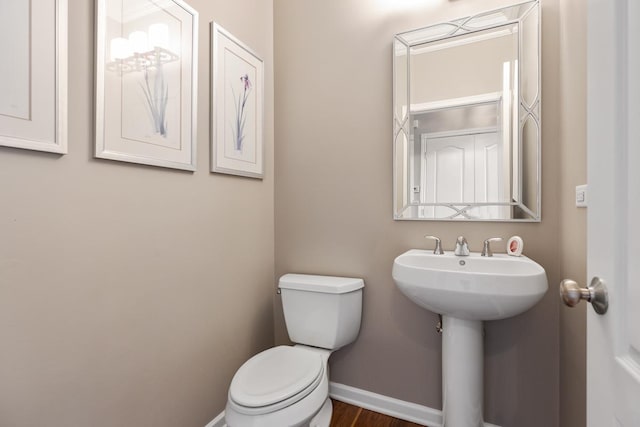 bathroom featuring sink, wood-type flooring, and toilet