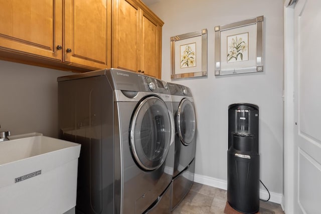 laundry area featuring washer and dryer, sink, and cabinets