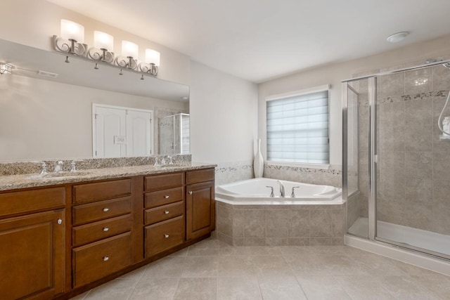 bathroom featuring tile patterned flooring, shower with separate bathtub, and vanity