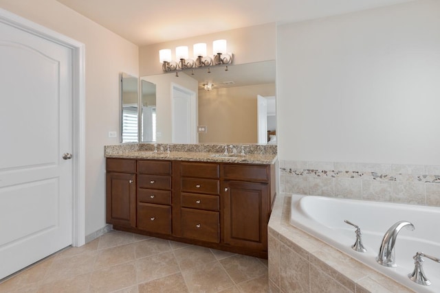 bathroom featuring tile patterned floors, vanity, and tiled bath