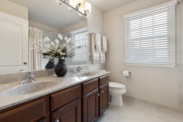 bathroom with tile patterned flooring, vanity, toilet, and walk in shower