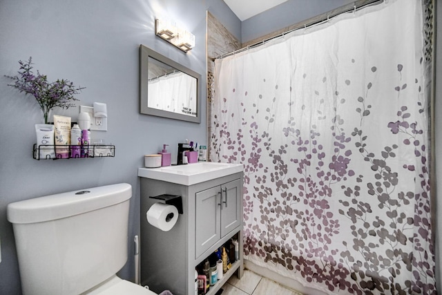 bathroom featuring tile patterned flooring, vanity, toilet, and walk in shower