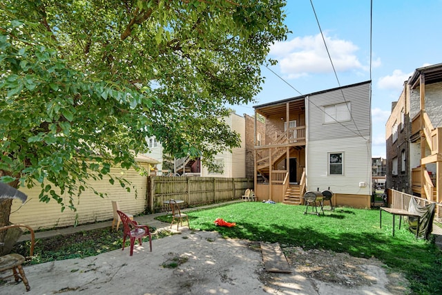 rear view of property featuring a lawn and a patio area