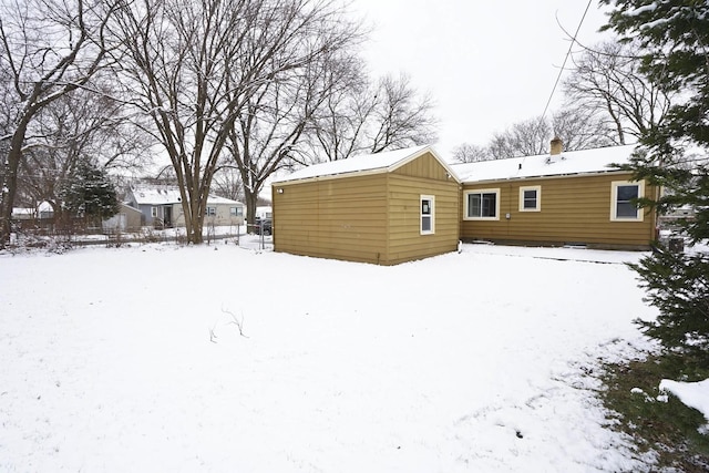 view of snow covered rear of property