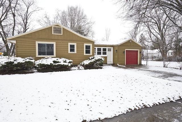 snow covered rear of property with a garage