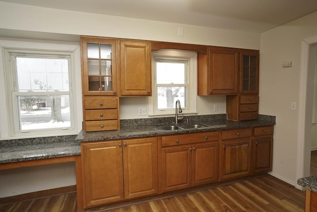 kitchen featuring dark hardwood / wood-style floors, dark stone countertops, and sink