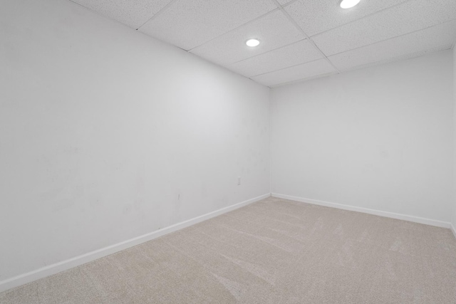 unfurnished room featuring a drop ceiling and carpet