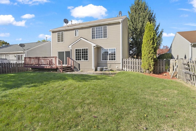 rear view of property featuring a lawn and a wooden deck