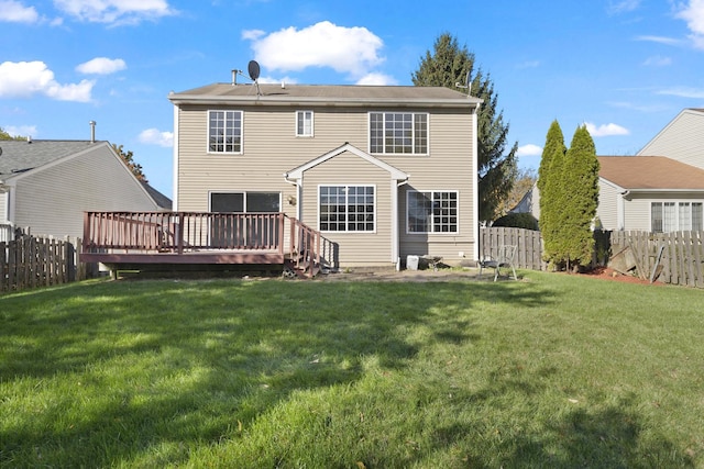 back of house featuring a lawn and a wooden deck