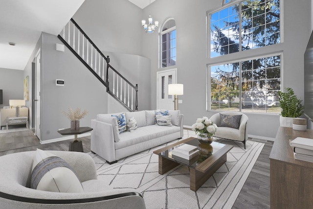 living room featuring a high ceiling, hardwood / wood-style flooring, and an inviting chandelier