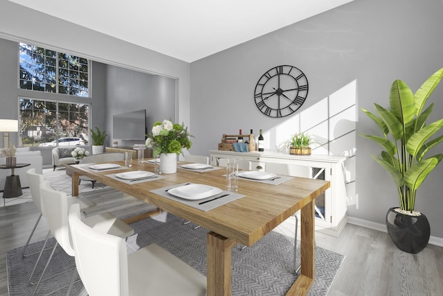 dining room with hardwood / wood-style flooring and a high ceiling