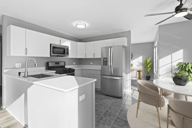 kitchen featuring white cabinets, sink, kitchen peninsula, and stainless steel appliances