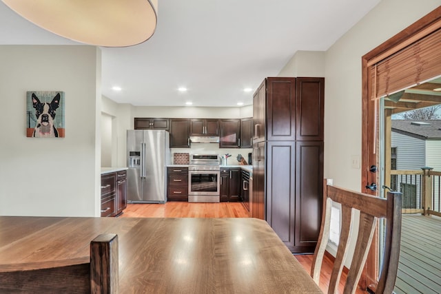 kitchen featuring dark brown cabinets, light wood-type flooring, and stainless steel appliances