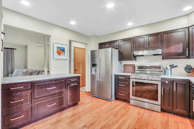 kitchen with light stone countertops, appliances with stainless steel finishes, and light wood-type flooring