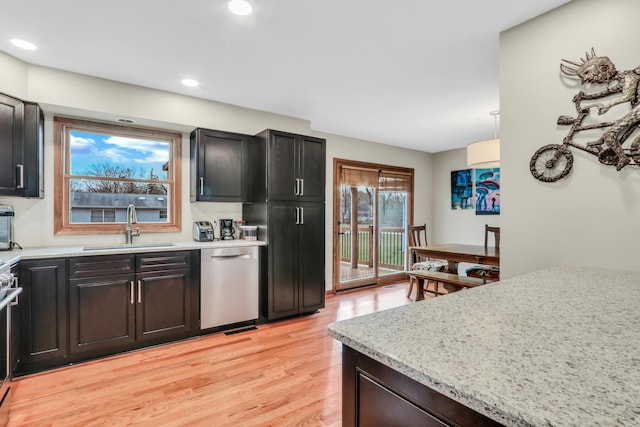 kitchen with sink, light hardwood / wood-style flooring, dishwasher, range, and hanging light fixtures