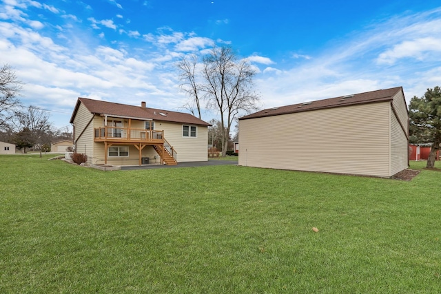 rear view of house featuring a lawn and a wooden deck